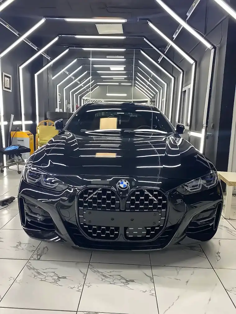 Işık tünelinde parlak siyah BMW 4 Serisi, önden